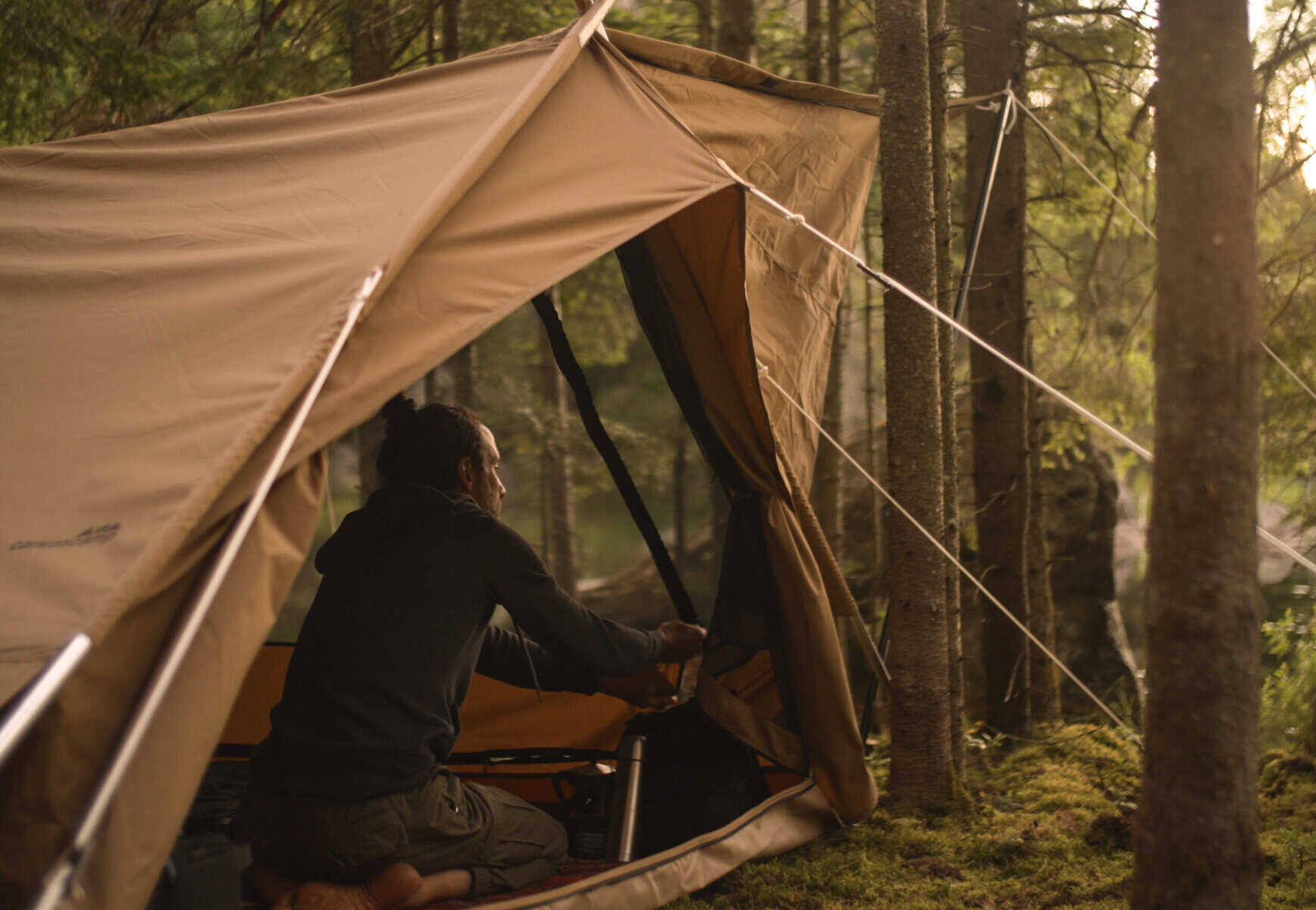 Gemütlicher Campingplatz mit Zelt in Waldnähe, Natur, Outdoor-Abenteuer, Camping im Grünen, abenteuerliche Reise, Entspannung im Wald, Naturerlebnis, Zelten im Wald, Campingausrüstung, Naturtourismus.