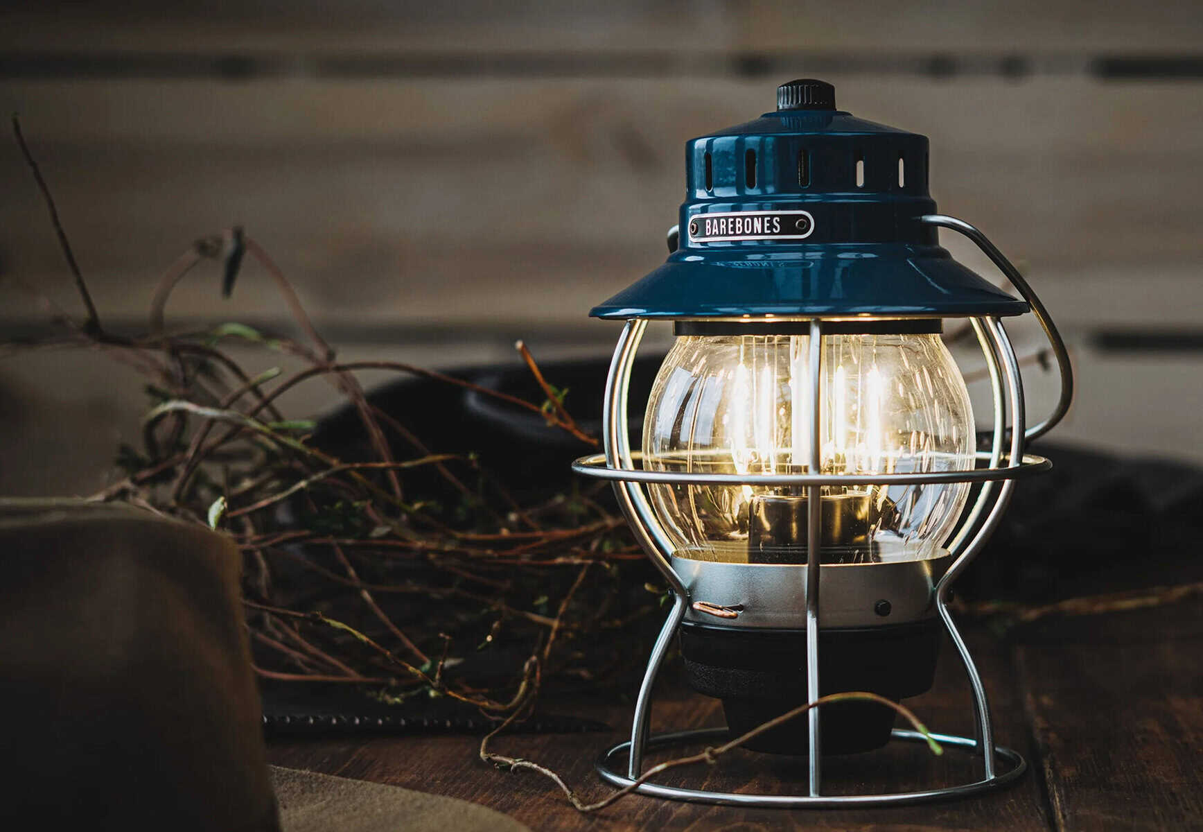 Schwarz-blaue Vintage-Outdoor-Lampe mit Glühbirne, ideal für Camping und Natur.