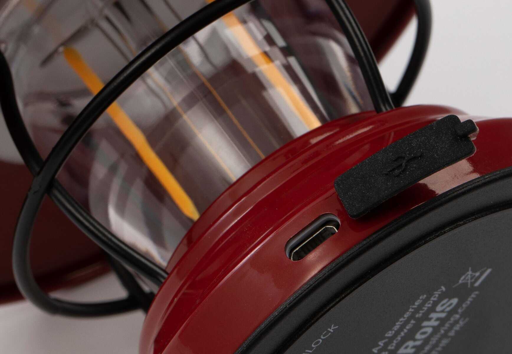 Leuchtende Laterne mit rotem Griff und USB-Anschluss, ideal für Notfälle und Camping, langlebig und zuverlässig.