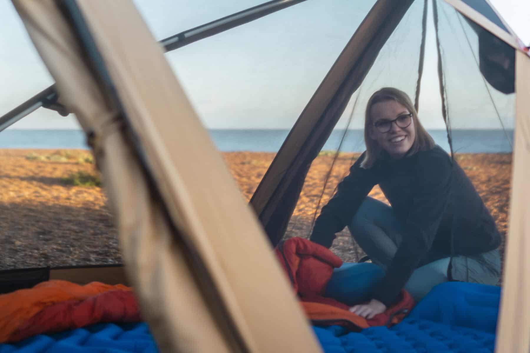 Gemütliches Zelt am Strand mit lachender Frau, Camping am Meer, Urlaub, Outdoor, Freizeit, Teide, Sonne, Natur, Campingplatz, Abenteuer, Entspannung, Reise, Sommer, Erholung, Lifestyle.