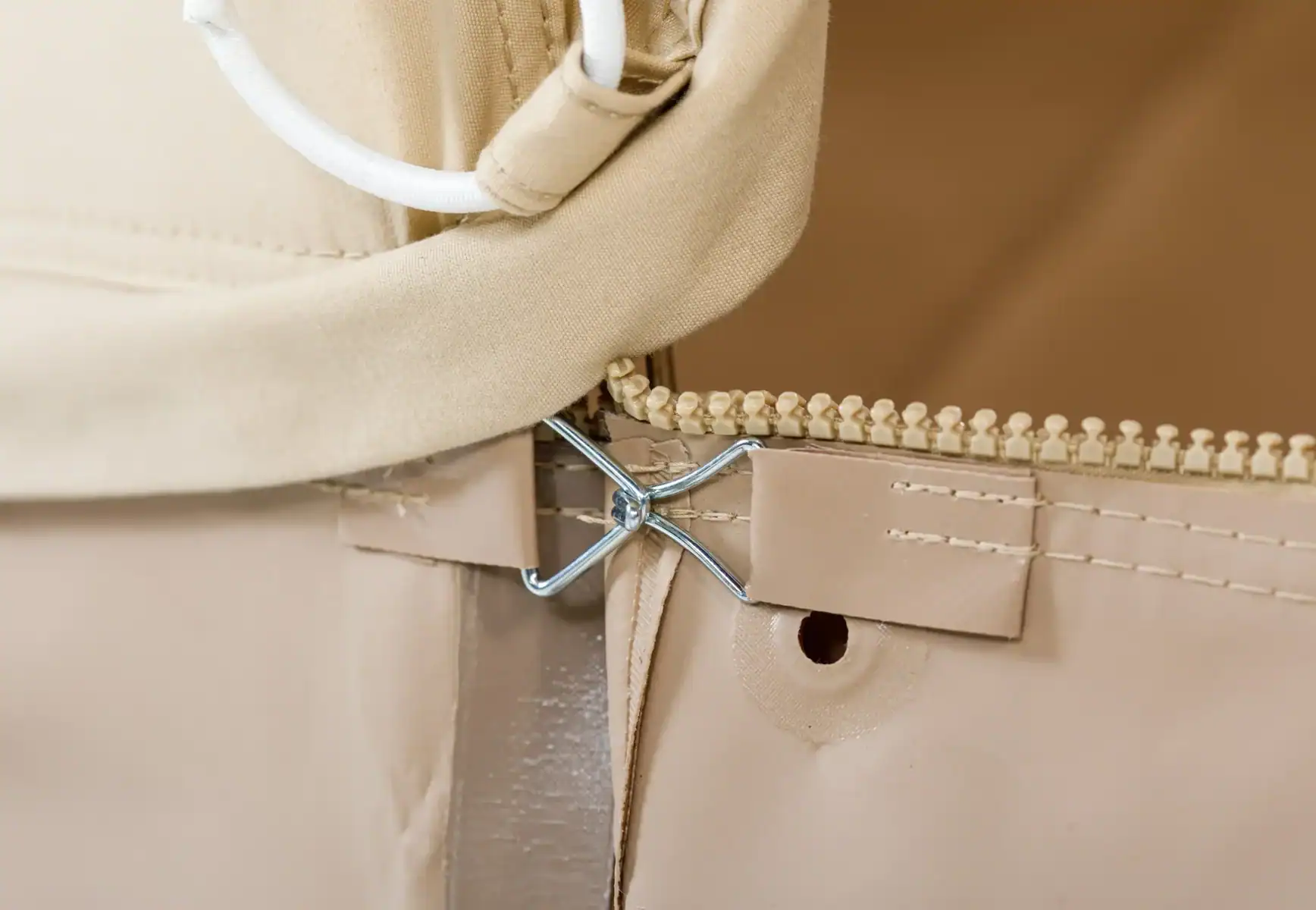 Fein gearbeiteter Reißverschluss und Gürtelverschluss in Nude-Tönen, hochwertige Modeaccessoires.