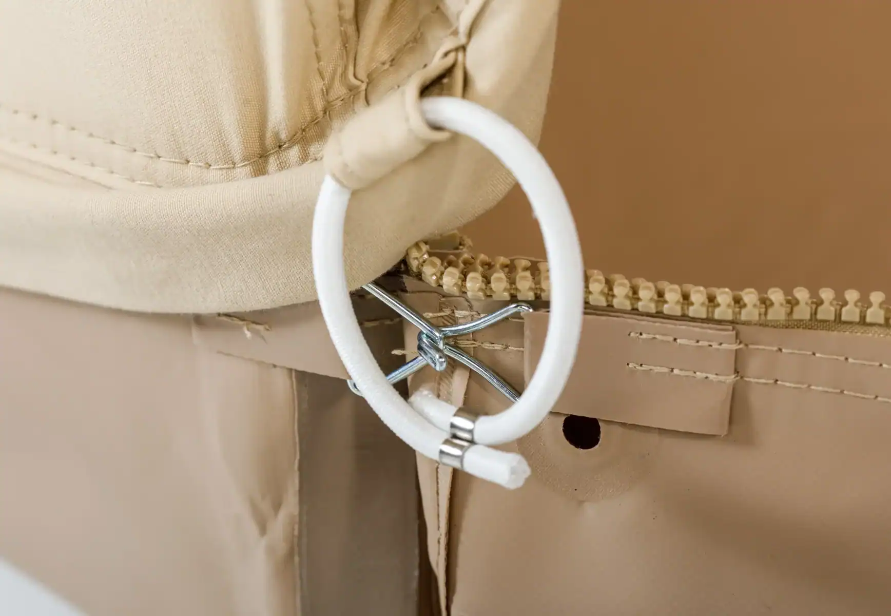 Robuster Reißverschluss mit hochwertiger Verarbeitung auf einem beigefarbenen Stoff, ideal für Taschen und Accessoires. Zeigt Details der langlebigen Qualität und präzisen Näharbeit.