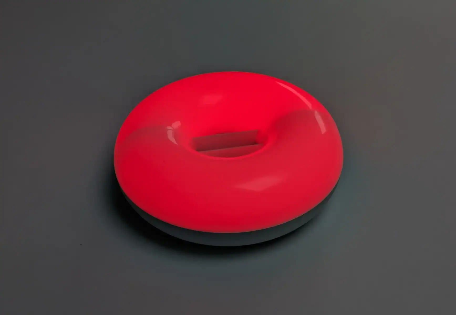 Roter Silikon-Badeball auf grauem Hintergrund.