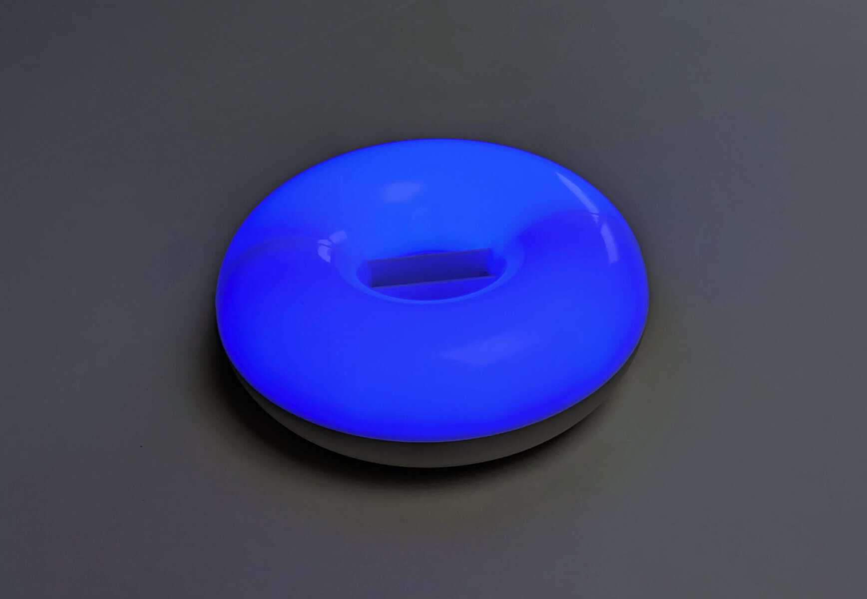 Leuchtender blauer, runder Aromalampe mit sanftem Licht in dunklem Raum.