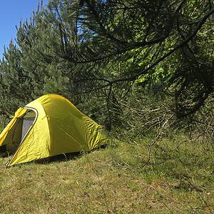 Zweipersonen-Zelt aus leichtem Material, ideal für Trekking und Camping, perfekt für Outdoor-Abenteuer, nur 2 kg schwer, in einer natürlichen Umgebung mit Bäumen und Wiese.