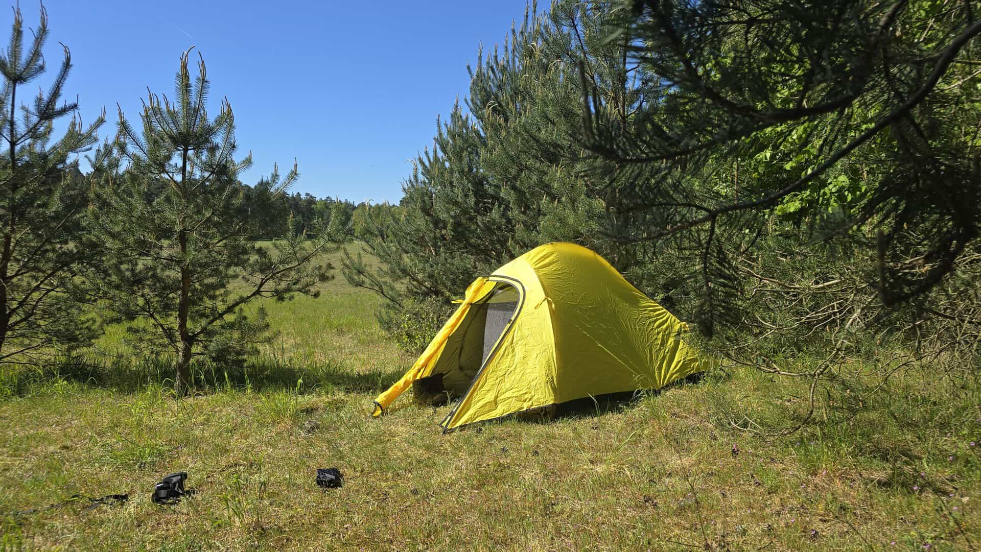 Zweipersonen-Zelt aus leichtem Material, ideal für Trekking und Camping, perfekt für Outdoor-Abenteuer, nur 2 kg schwer, in einer natürlichen Umgebung mit Bäumen und Wiese.