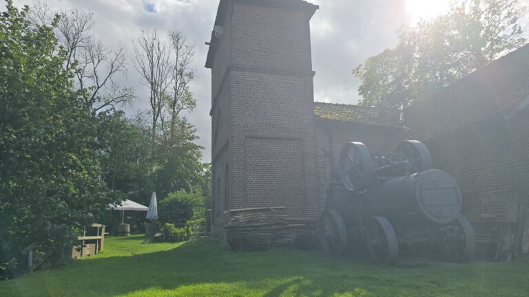 Historische Düvelsteine bei Heiden, umgeben von Natur und alten Gebäuden, im Sonnenlicht fotografiert.